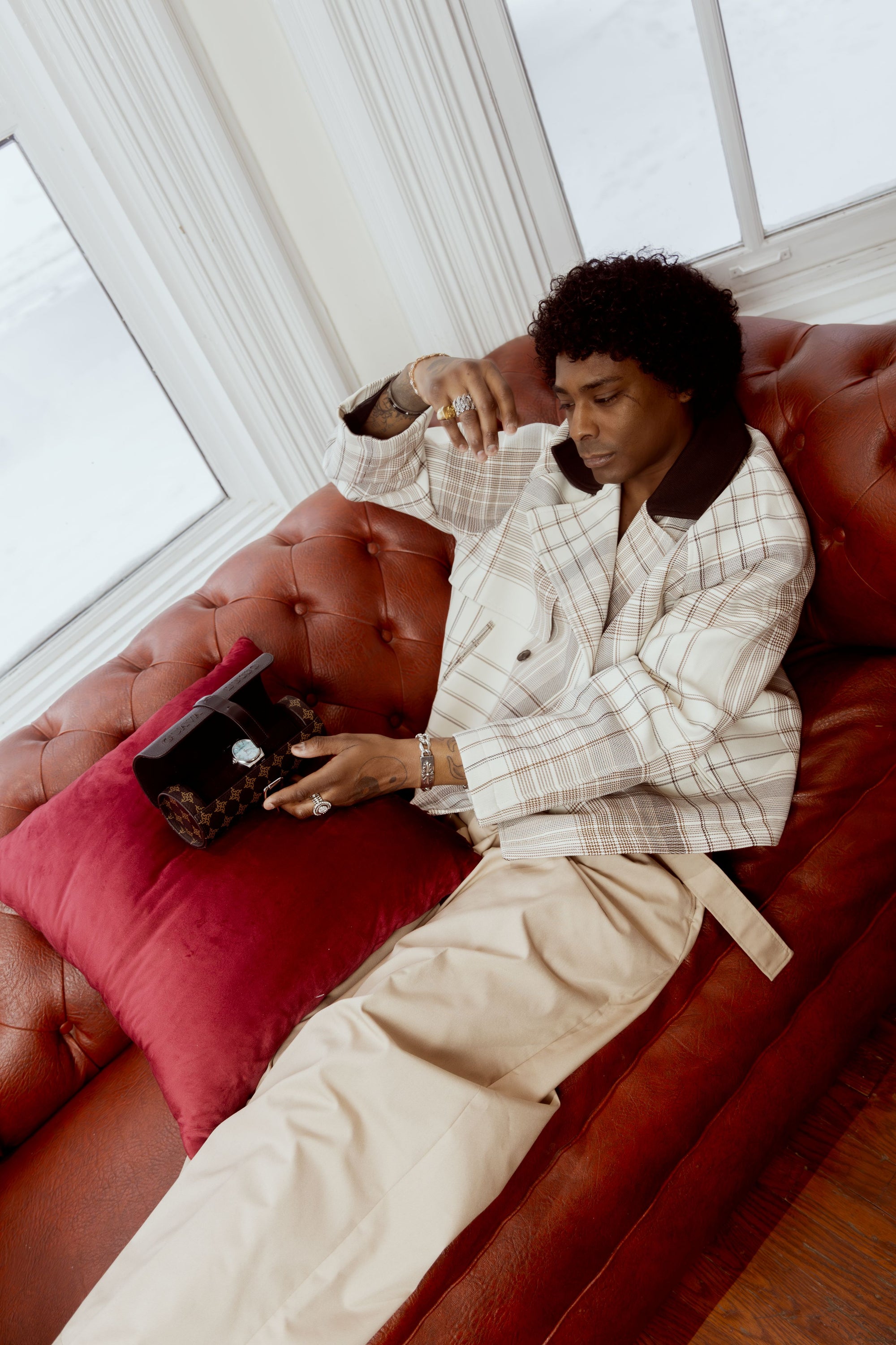 Person sitting on a red couch holding a watch case