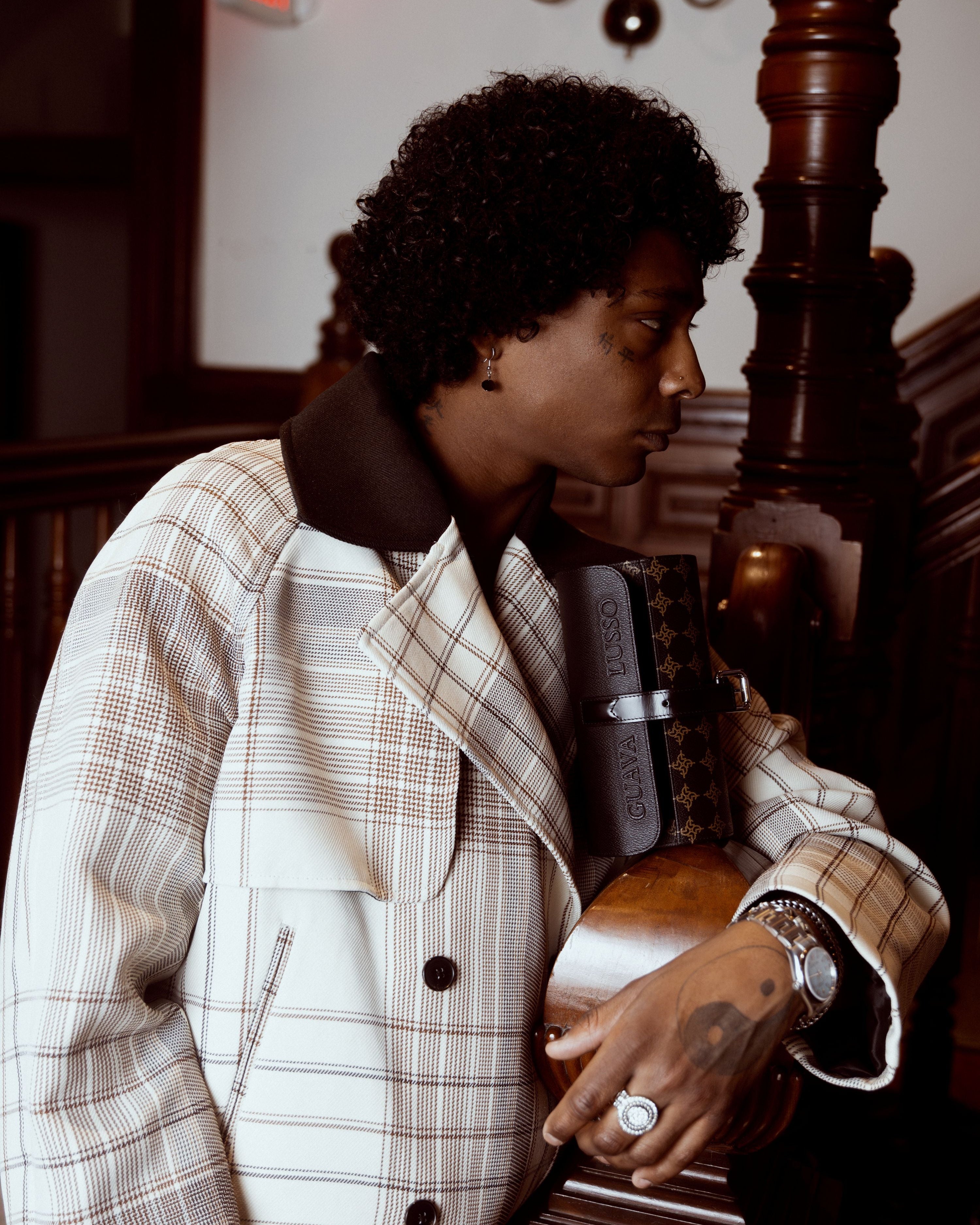 Person wearing a plaid jacket in an indoor setting with wooden furniture